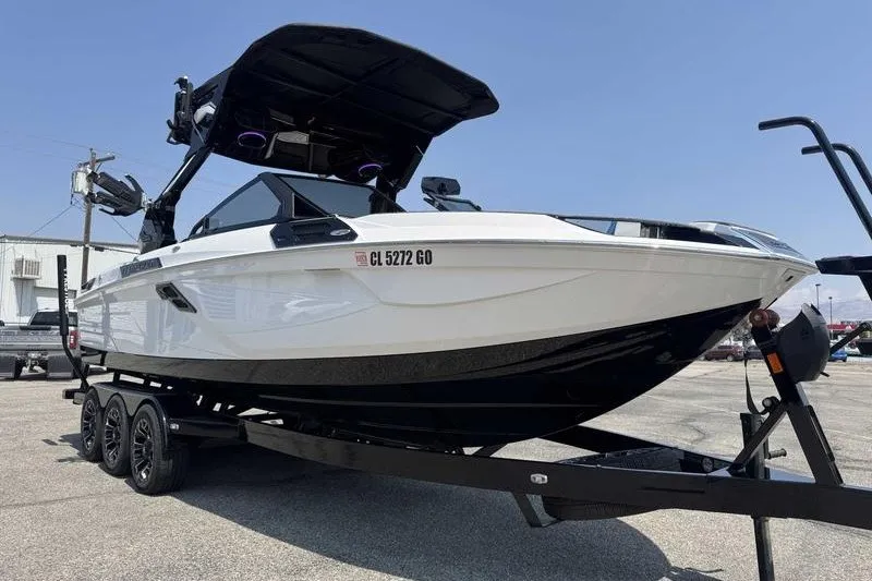 Slide: The Image of 2025 Centurion Ri245 boat on trailer, sleek design, black and white color scheme. - 8