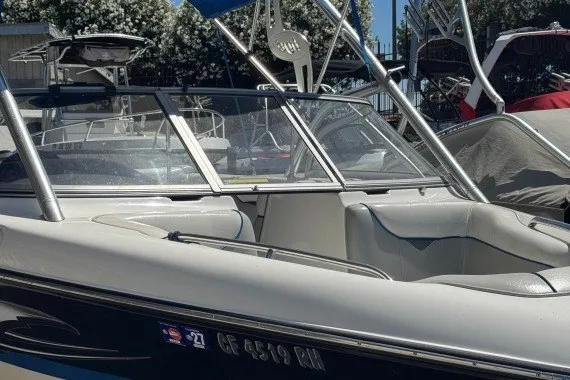 The Image of 2006 Tige 22i boat with sleek design, docked under clear blue sky. - 1