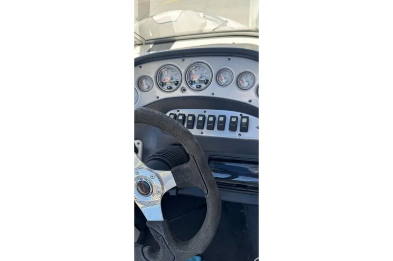Slide: The Image of Dashboard of a 2006 Tige 22i boat with steering wheel and gauges. - 2