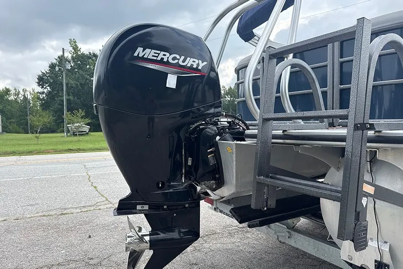 Slide: The Image of 2023 Bentley Pontoons Legacy Navigator 223 with Mercury outboard motor, parked on a trailer. - 11