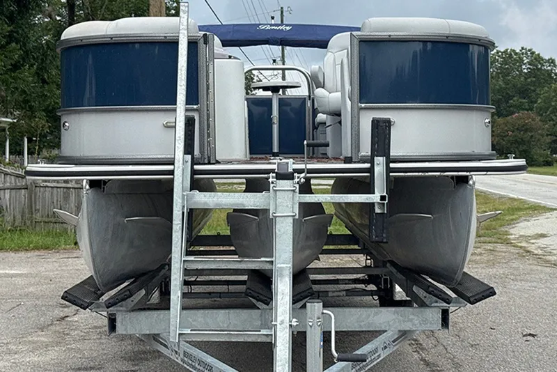 Slide: The Image of 2023 Bentley Pontoons Legacy Navigator 223 on trailer, showcasing sleek design and modern features. - 2