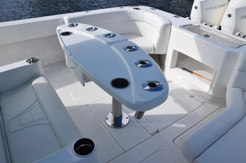 Slide: The Image of 2022 SeaVee 390Z boat interior with seating and table, featuring multiple cup holders. - 11
