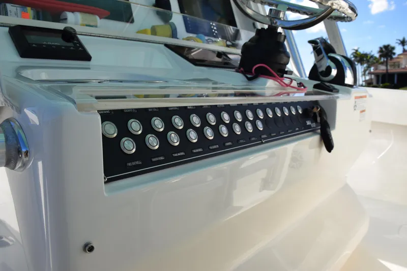Slide: The Image of Control panel of a 2022 SeaVee 390Z boat with multiple buttons and steering wheel. - 21