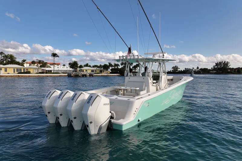 Slide: The Image of 2022 SeaVee 390Z boat with four outboard engines on calm water, coastal homes in background. - 4