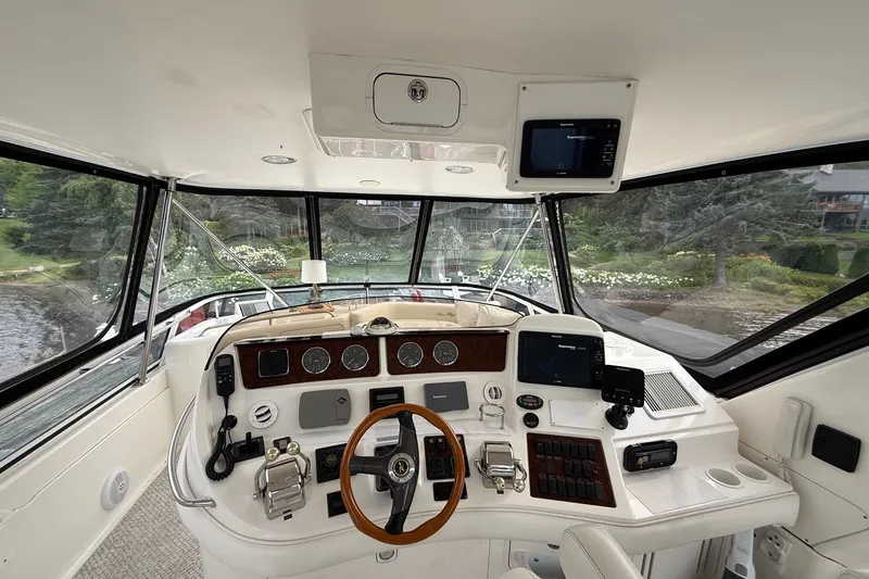 Slide: The Image of 2004 Sea Ray 480 Sedan Bridge helm with navigation instruments and panoramic windows. - 16