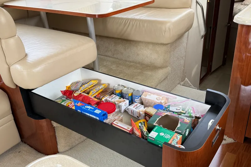 Slide: The Image of Storage drawer with snacks and canned goods in a 2004 Sea Ray 480 Sedan Bridge yacht. - 32