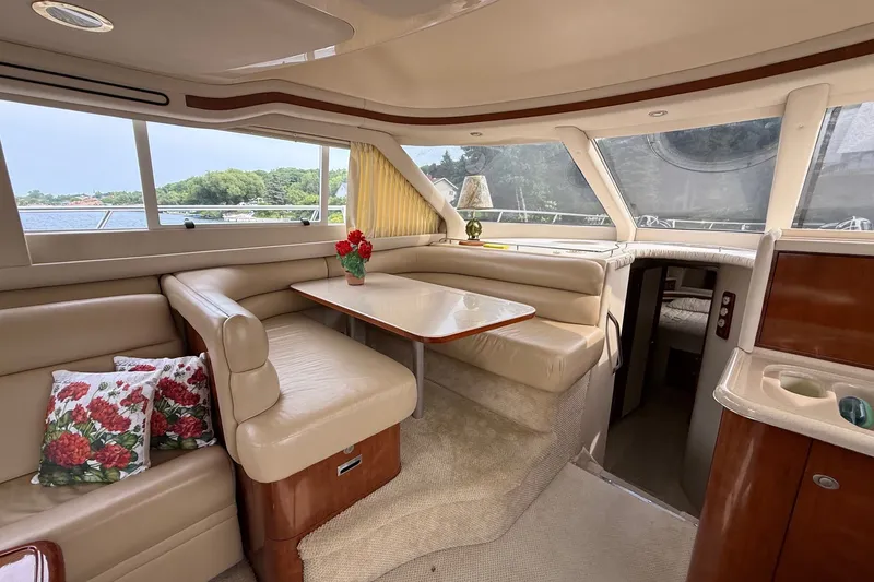 Slide: The Image of Luxurious interior of 2004 Sea Ray 480 Sedan Bridge yacht with elegant seating and table. - 27