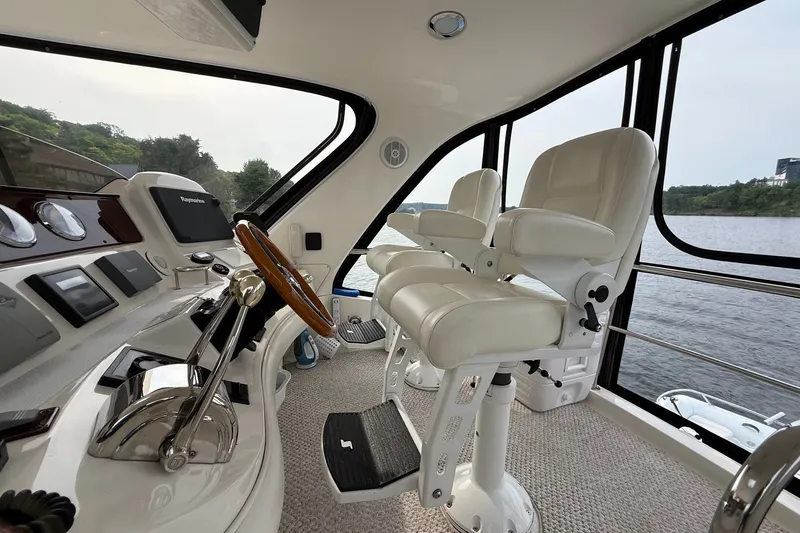 Slide: The Image of Luxurious 2004 Sea Ray 480 Sedan Bridge helm with plush seating and advanced controls. - 14