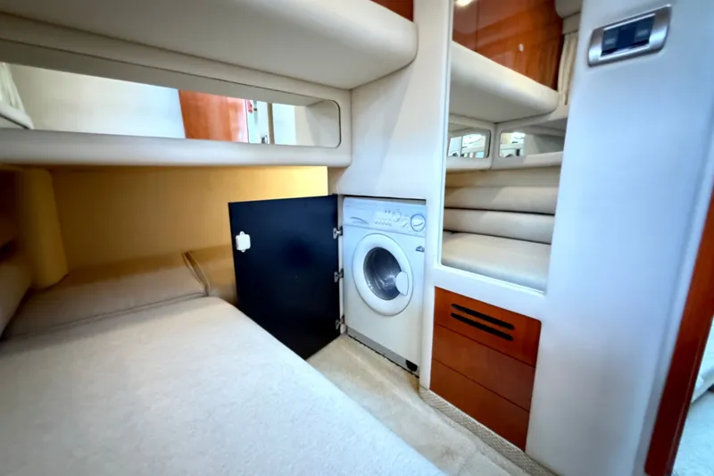 Slide: The Image of 2004 Sea Ray 480 Sedan Bridge interior with built-in washing machine and cozy sleeping area. - 42