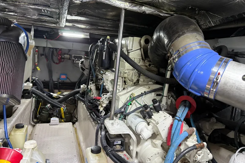 Slide: The Image of Engine room of a 2004 Sea Ray 480 Sedan Bridge, showcasing mechanical components and hoses. - 45