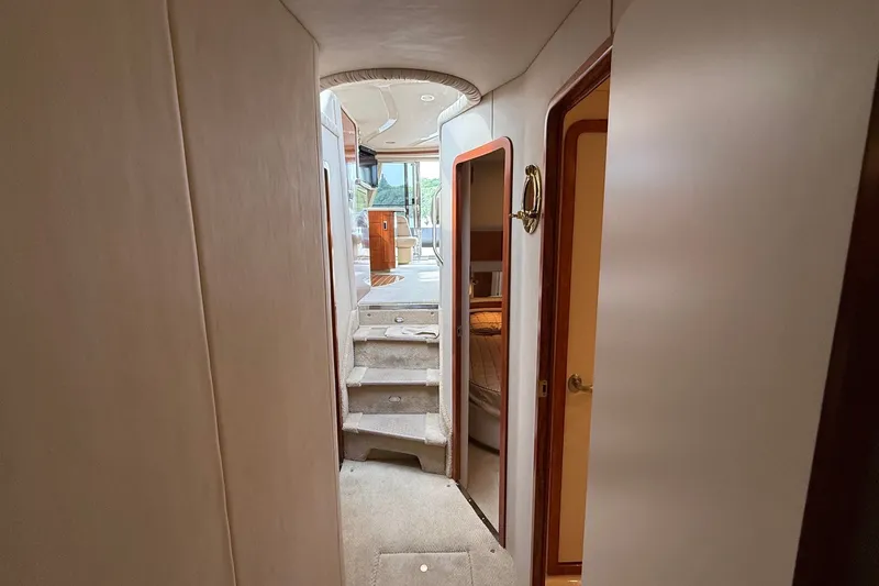 Slide: The Image of Interior hallway of 2004 Sea Ray 480 Sedan Bridge yacht, featuring stairs and cabin doors. - 33