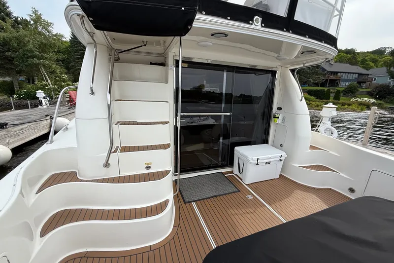 Slide: The Image of 2004 Sea Ray 480 Sedan Bridge yacht with teak deck and staircase, docked by the water. - 13