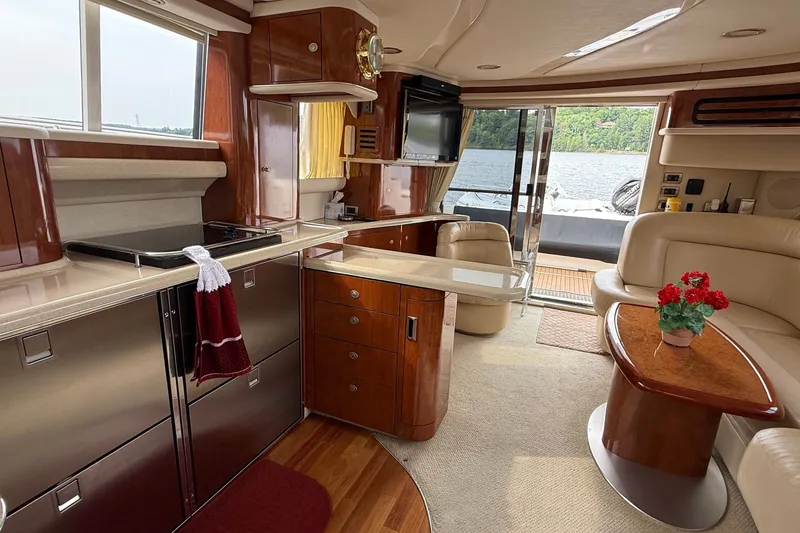 Slide: The Image of Luxurious 2004 Sea Ray 480 Sedan Bridge yacht interior with elegant wood finishes and lake view. - 30