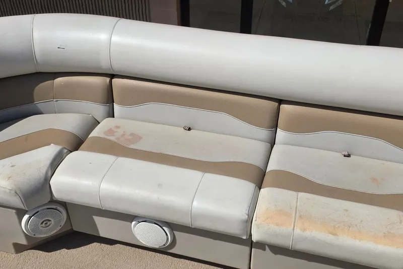 Slide: The Image of 2003 Northwood 2223 TRADITIONS boat seating with beige and white upholstery, featuring built-in speakers. - 10