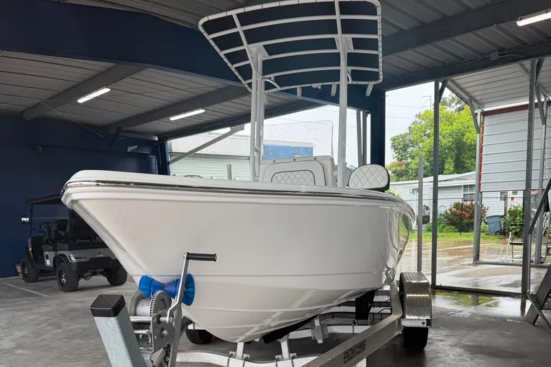 Slide: The Image of 2025 Clearwater 21 Bay boat on trailer in covered storage area. - 1