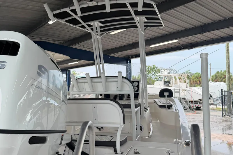 Slide: The Image of 2025 Clearwater 21 Bay boat with Suzuki engine under a covered dock. - 4