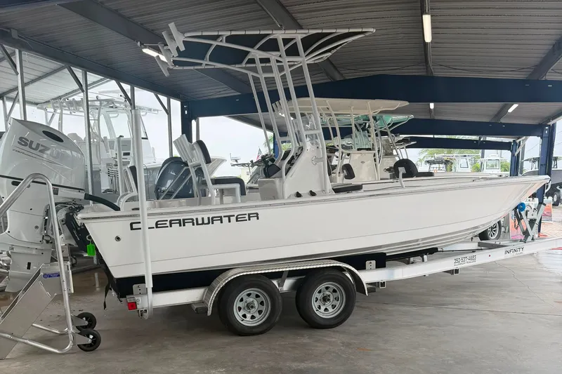 The Image of 2025 Clearwater 21 Bay boat on trailer in showroom, featuring sleek design and modern equipment. - 0