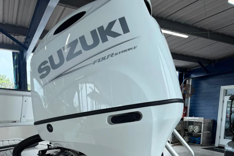 Slide: The Image of Outboard motor on a 2025 Clearwater 21 Bay boat in a garage setting. - 12