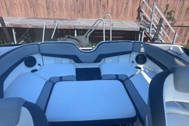 Slide: The Image of 2013 Yamaha Boats 212X interior seating with speakers, dock in background. - 9