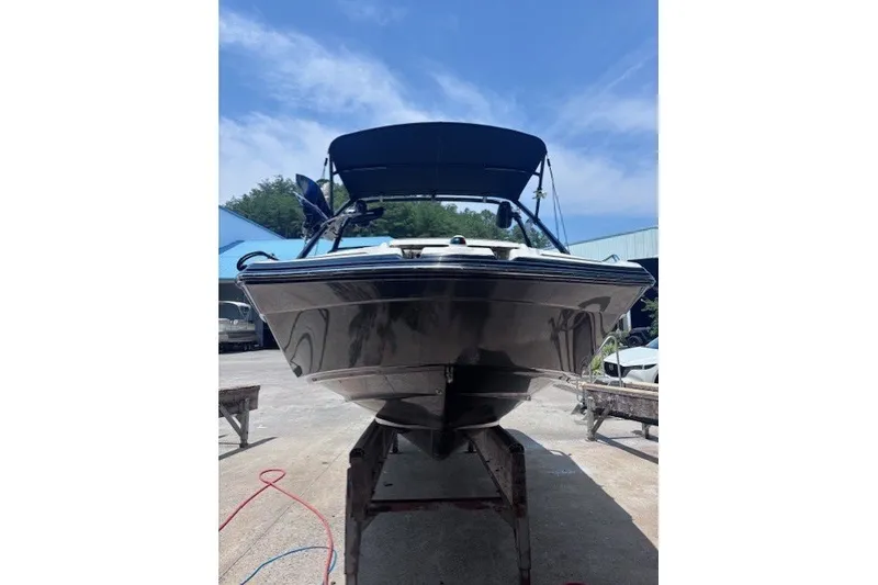 Slide: The Image of 2013 Yamaha Boats 212X on trailer, black hull, outdoor setting, clear sky. - 14