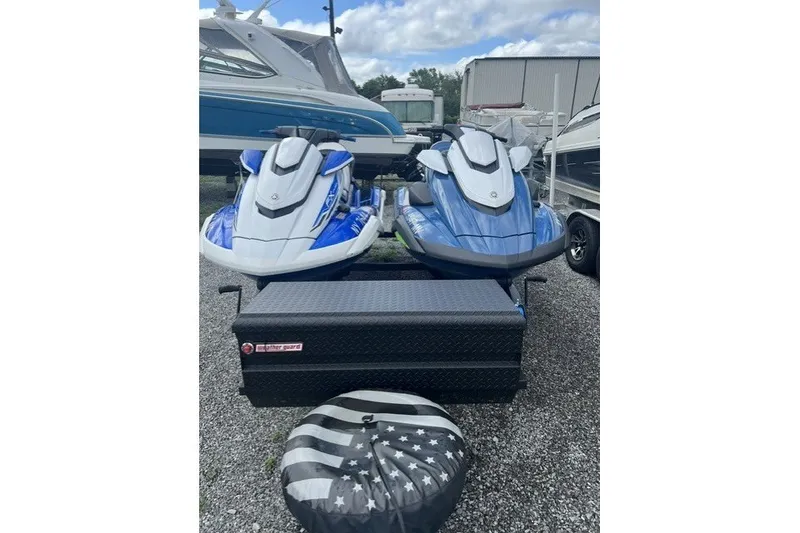 The Image of 2024 Yamaha PWC FX Cruiser SVHO jet skis parked on gravel lot. - 1