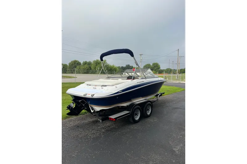 Slide: The Image of 2010 Four Winns H210 boat on trailer, parked outdoors with overcast sky. - 4
