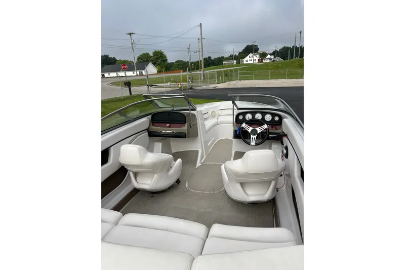 Slide: The Image of 2010 Four Winns H210 boat interior with white seating and dashboard view. - 5