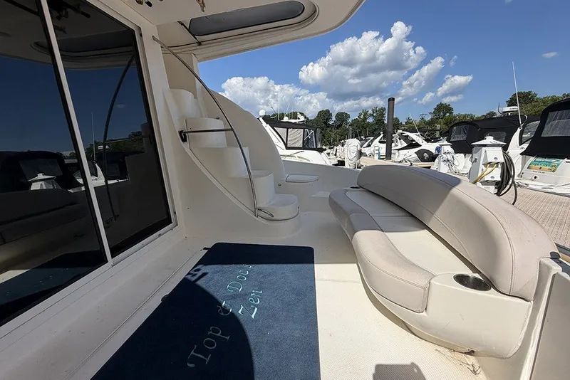 Slide: The Image of 2009 Meridian 391 Sedan yacht deck with seating and staircase under a clear sky. - 5