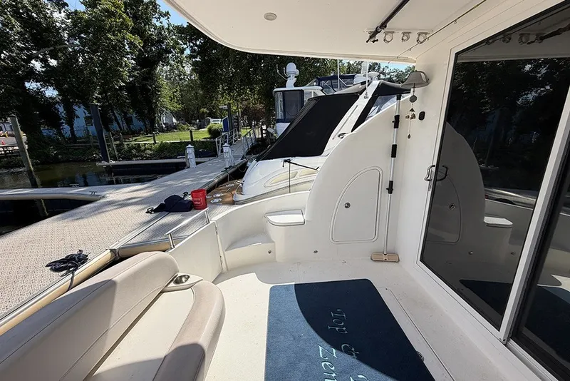 Slide: The Image of 2009 Meridian 391 Sedan yacht docked, featuring spacious deck and seating area. - 7