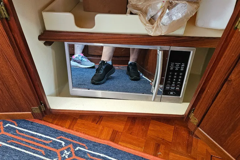 Slide: The Image of Microwave in a 1995 Maple Bay 27 boat, reflecting sneakers on a wooden floor. - 6