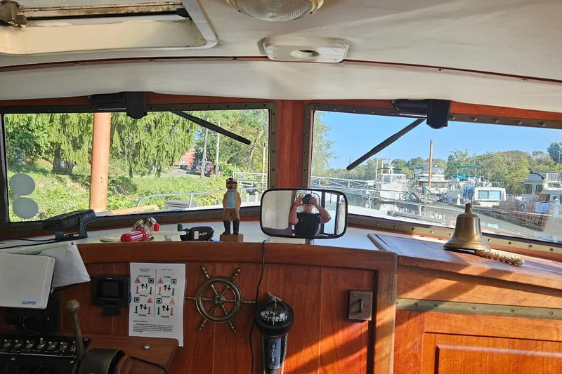 Slide: The Image of Interior view of a 1995 Maple Bay 27 boat cockpit with steering wheel and bell. - 3