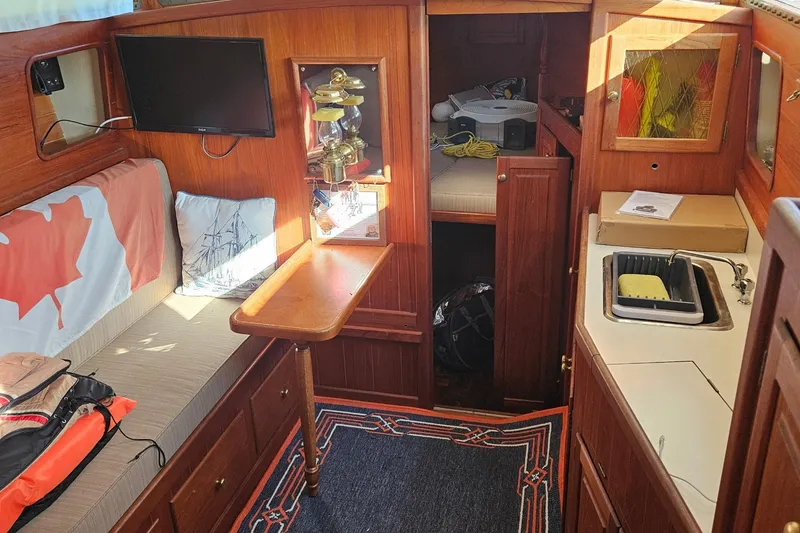 Slide: The Image of Interior of a 1995 Maple Bay 27 boat with cozy seating and kitchenette. - 4
