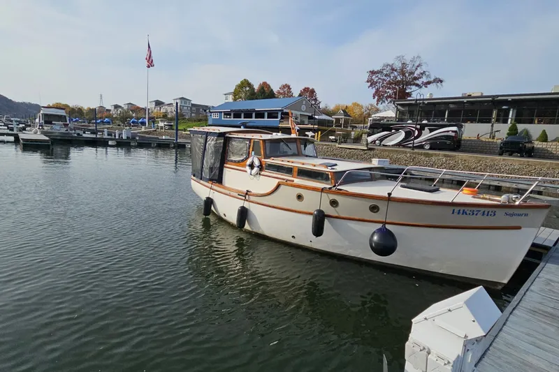 Slide: The Image of 1995 Maple Bay 27 boat docked at a marina with scenic background. - 7