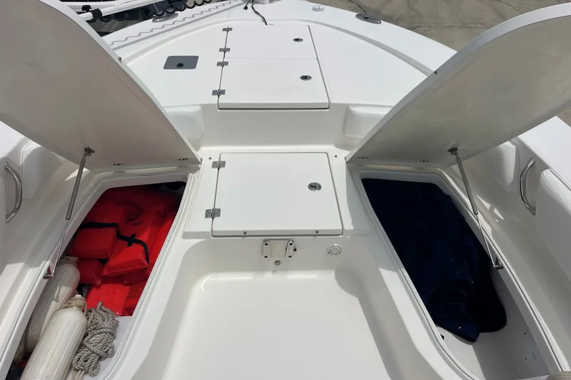 Slide: The Image of 2019 Robalo 246 Cayman boat storage compartments with life jackets and ropes. - 26
