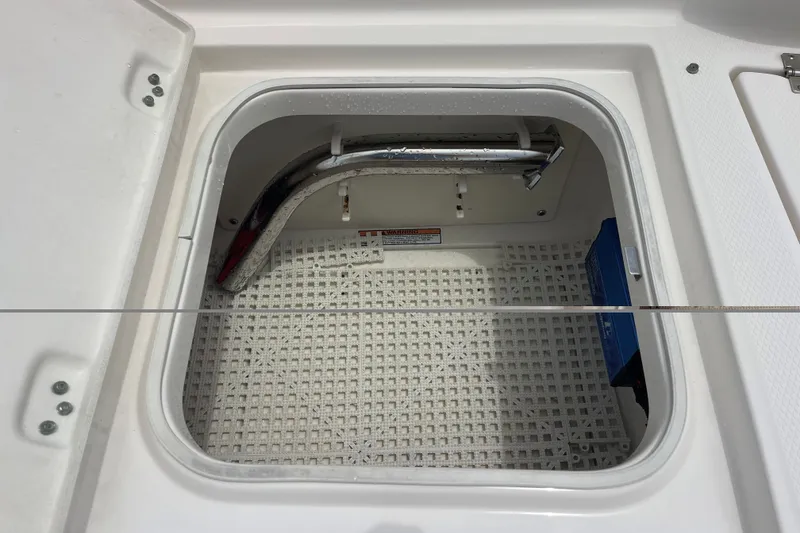 Slide: The Image of Open storage compartment on a 2019 Robalo 246 Cayman boat, featuring a clean interior. - 28
