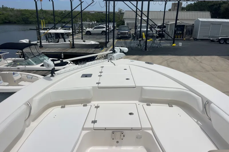 Slide: The Image of Bow view of 2019 Robalo 246 Cayman boat docked at marina. - 25