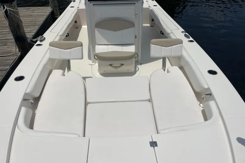 Slide: The Image of 2019 Robalo 246 Cayman boat interior with white seating and storage compartments. - 17