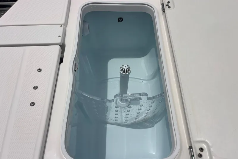 Slide: The Image of Livewell compartment on a 2019 Robalo 246 Cayman boat, featuring a clean interior. - 19