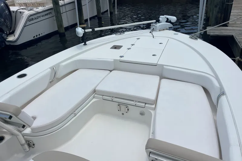 Slide: The Image of 2019 Robalo 246 Cayman boat with spacious seating and storage, docked near water. - 16