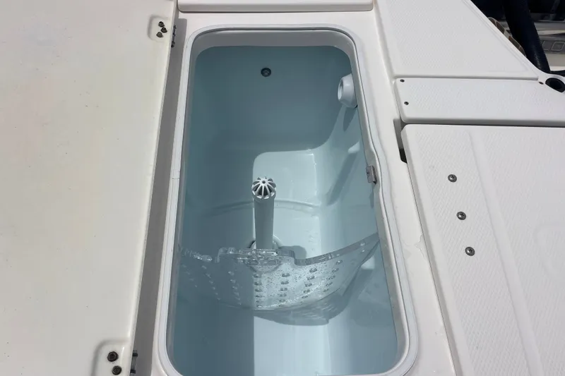 Slide: The Image of Livewell compartment on a 2019 Robalo 246 Cayman boat, featuring a clean, white interior. - 20