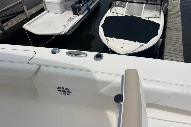 Slide: The Image of 2019 Robalo 246 Cayman boat docked, featuring sleek white seating and deck details. - 35