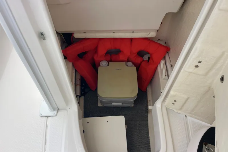 Slide: The Image of 2019 Robalo 246 Cayman boat storage with life jackets and portable toilet. - 29