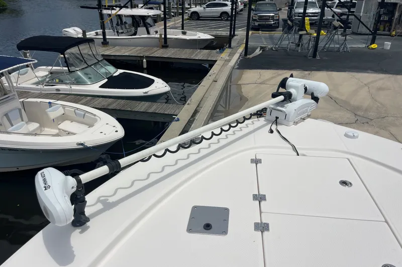 Slide: The Image of 2019 Robalo 246 Cayman boat docked with trolling motor, surrounded by other boats. - 33
