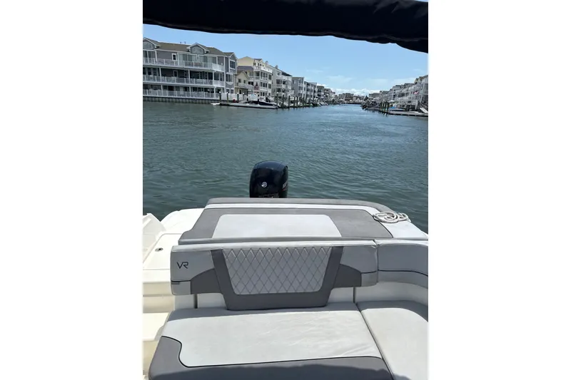 Slide: The Image of 2023 Bayliner VR6 Bowrider OB on a scenic waterfront, showcasing luxurious seating and modern design. - 8