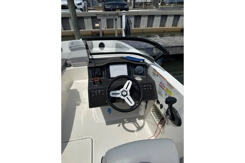 Slide: The Image of 2023 Bayliner VR6 Bowrider OB cockpit with steering wheel and control panel. - 2