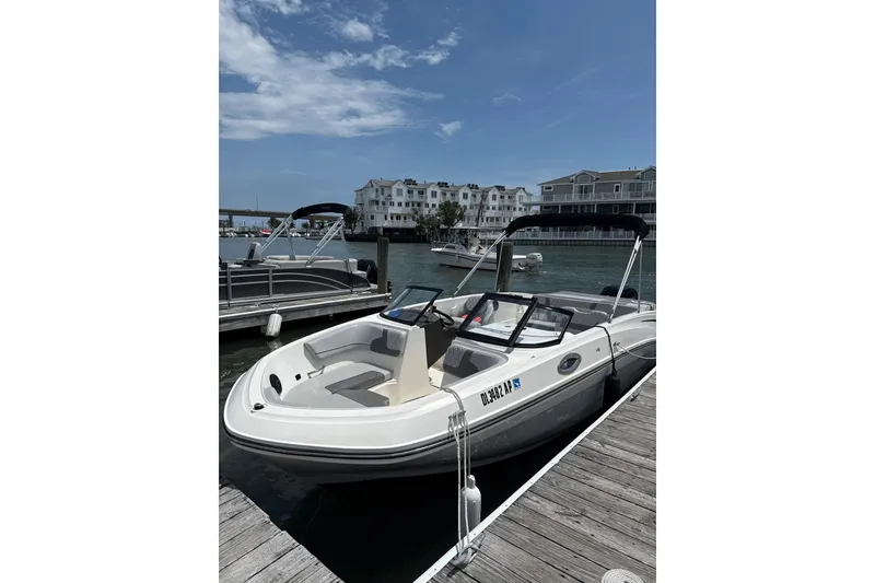 The Image of 2023 Bayliner VR6 Bowrider OB docked at a marina under a clear blue sky. - 1