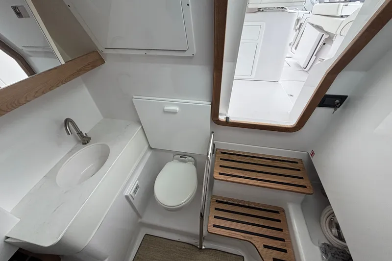 Slide: The Image of Modern bathroom interior of 2027 Bertram 34 CC boat with sink, toilet, and wooden accents. - 11