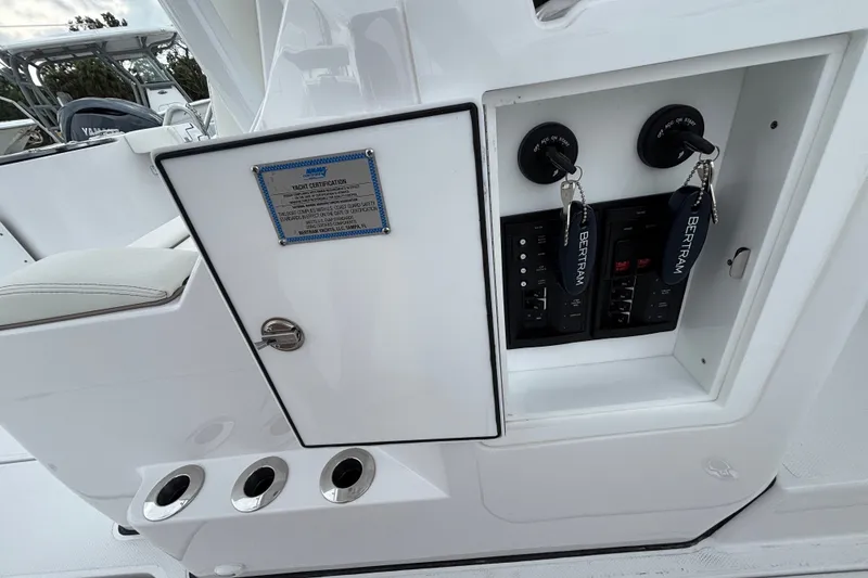 Slide: The Image of 2027 Bertram 34 CC yacht control panel with keys and certification plaque. - 20