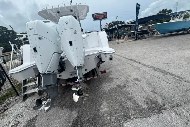 Slide: The Image of 2027 Bertram 34 CC boat with dual outboard engines in a marina setting. - 3