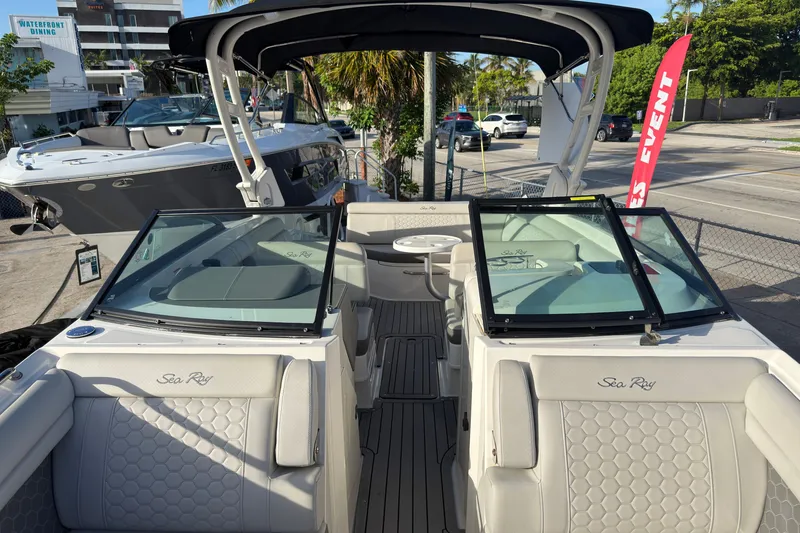 Slide: The Image of 2021 Sea Ray SDX 270 boat with luxurious seating and sleek design at a marina. - 14